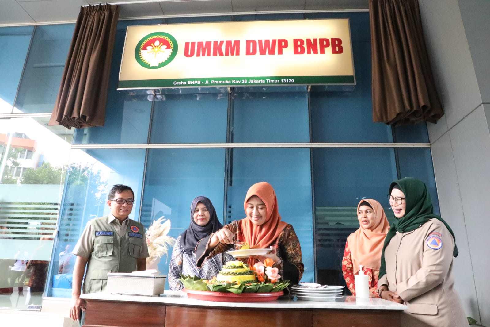 Plt Sekretaris Utama BNPB Rustian (rompi hijau), Deputi Bidang Pencegahan BNPB Prasinta Dewi (kerudung hijau) dan Ketua DWP BNPB Uke Suharyanto (baju hitam dengan kerudung orange) meresmikan Toko UMKM DWP BNPB yang bertempat di Lobi Selatan Gedung Graha BNPB Jakarta, pada Kamis (8/6).